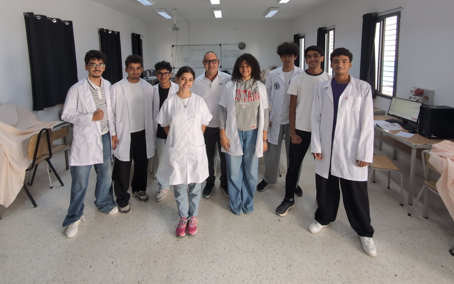 A technology teacher with his students in the technology lab