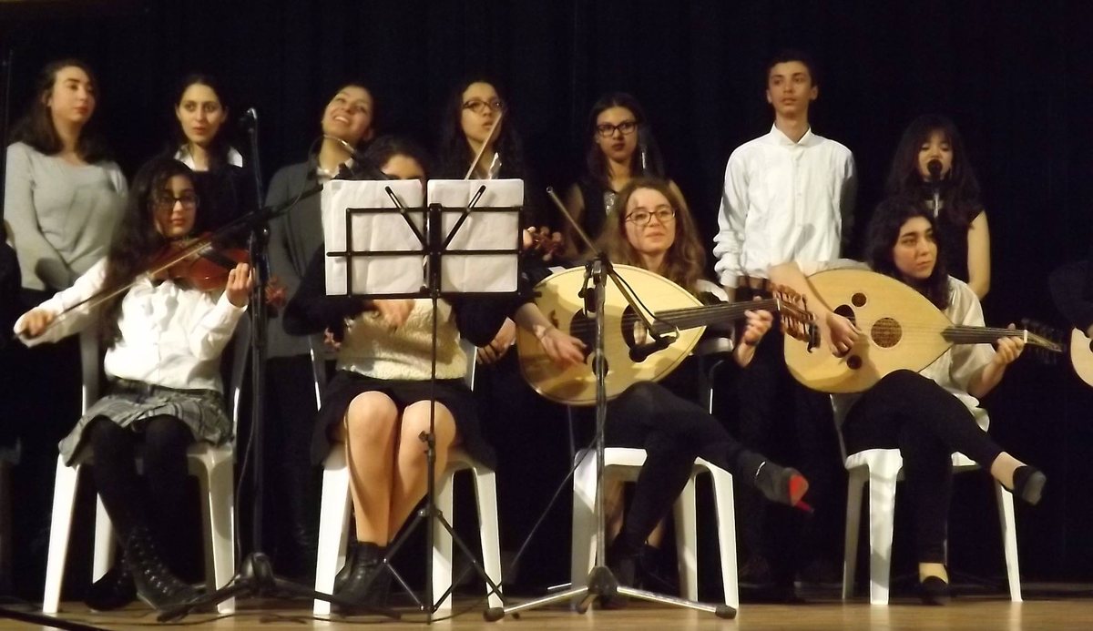 Students performing with violin and oud at a school concert